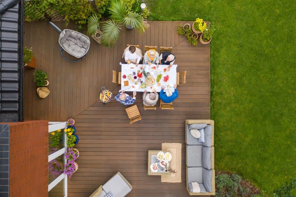 1. Cozy outdoor deck with dining area and surrounding greenery for gatherings.